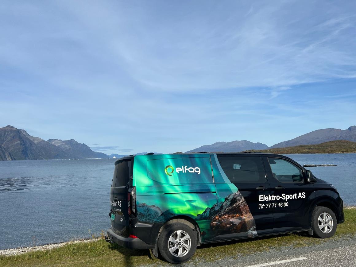Elektro-Sport servicebil med nordlys-dekor ved Lyngenfjorden